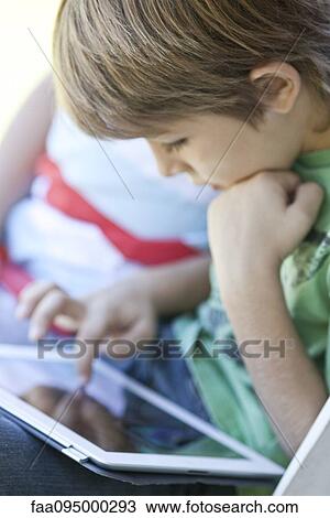 Stock Image - Boy using digital tablet. Fotosearch