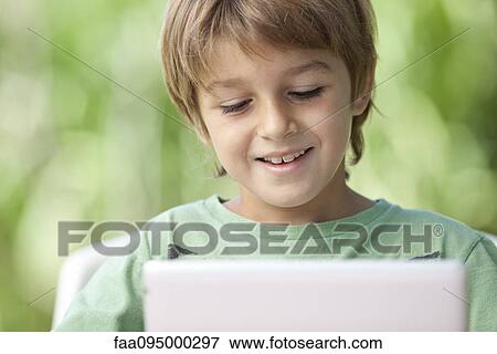 Stock Photo - Boy using digital tablet. Fotosearch