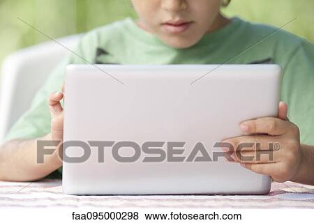 Stock Photo - Boy using digital tablet. Fotosearch
