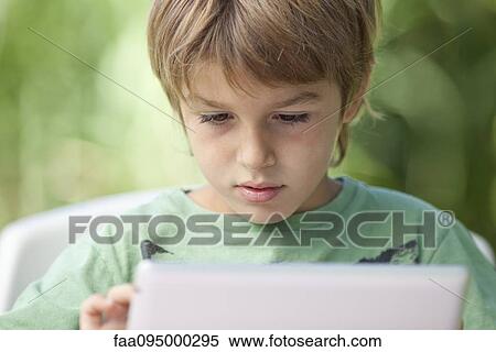Stock Photography - Boy using digital tablet. Fotosearch