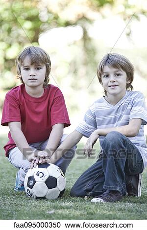 Boys crouching on field with soccer ball, portrait View Large Photo Image Stock Image - Boys crouching on field with soccer ball, portrait. Fotosearch