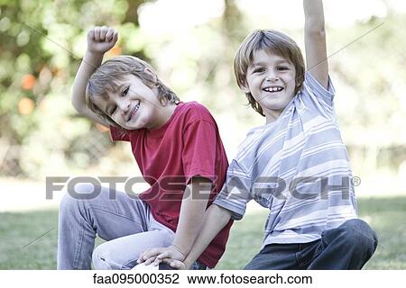 Boys crouching on field with soccer ball, both cheering with arms in air View Large Photo Image Stock Image - Boys crouching on field with soccer ball, both cheering with arms in air. Fotosearch
