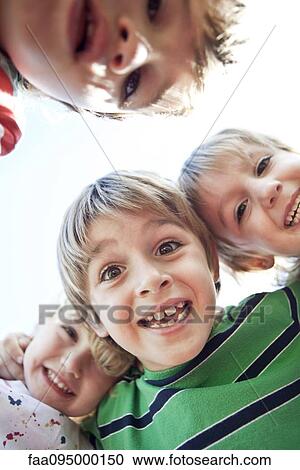 Boys huddling, smiling down at camera View Large Photo Image Stock Image - Boys huddling, smiling down at camera. Fotosearch