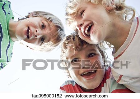 Boys huddling, smiling down at camera View Large Photo Image Stock Image - Boys huddling, smiling down at camera. Fotosearch