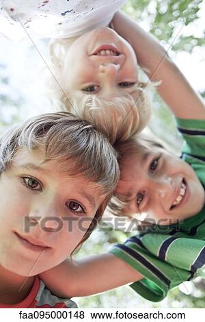 Boys huddling, smiling down at camera View Large Photo Image Stock Photo - Boys huddling, smiling down at camera. Fotosearch