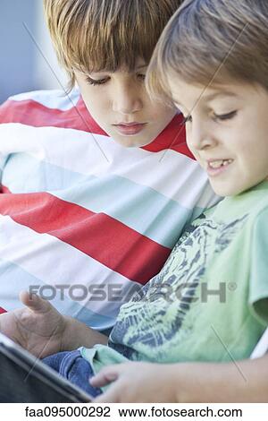 Stock Image - Boys using digital tablet. Fotosearch