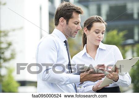 Picture - Business associates collaborating using digital tablet. Fotosearch