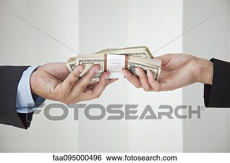 Businessman and businesswoman holding stacks of cash View Large Photo Image Stock Photograph - Businessman and businesswoman holding stacks of cash. Fotosearch