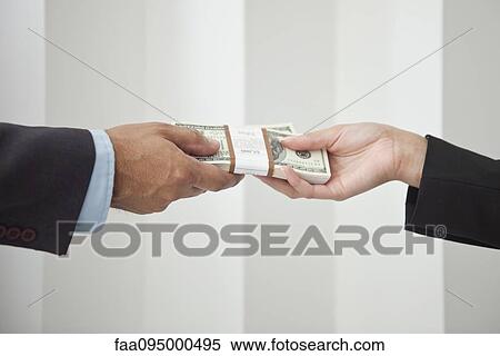 Businessman and businesswoman holding stacks of cash View Large Photo Image Stock Photography - Businessman and businesswoman holding stacks of cash. Fotosearch