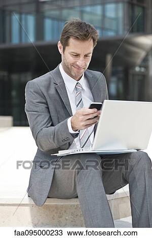 Businessman multitasking while working outdoors View Large Photo Image Stock Image - Businessman multitasking while working outdoors. Fotosearch
