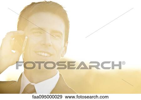 Stock Photo - Businessman talking on cell phone, portrait. Fotosearch