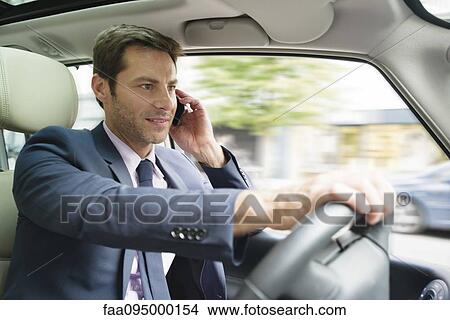 Businessman talking on cell phone while driving View Large Photo Image Picture - Businessman talking on cell phone while driving. Fotosearch