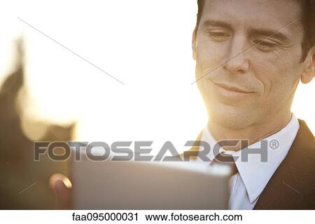 Businessman using digital tablet, backlit View Large Photo Image Stock Image - Businessman using digital tablet, backlit. Fotosearch