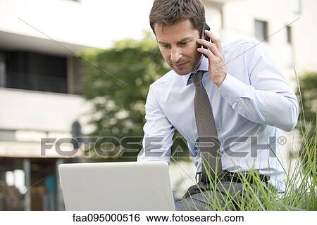 Stock Photograph - Businessman working outdoors. Fotosearch