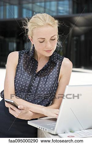 Businesswoman using laptop working outdoors View Large Photo Image Stock Image - Businesswoman using laptop working outdoors. Fotosearch