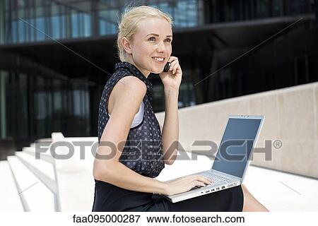 Stock Photo - Businesswoman using laptop working outdoors. Fotosearch