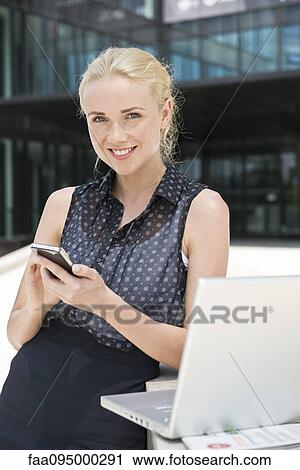 Stock Image - Businesswoman using smartphone. Fotosearch