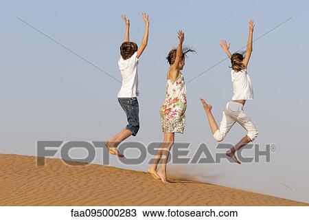 Children jumping on sand, rear view View Large Photo Image Stock Image - Children jumping on sand, rear view. Fotosearch