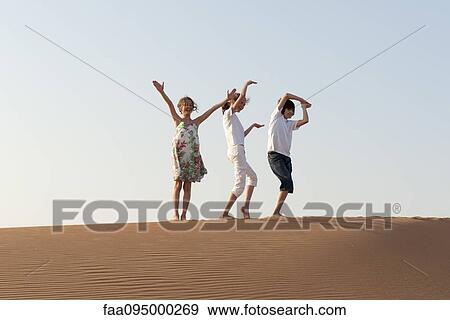 Stock Photo - Children walking in desert, making gestures with arms. Fotosearch