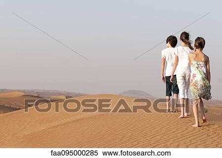 Children walking in desert, rear view View Large Photo Image Stock Photography - Children walking in desert, rear view. Fotosearch