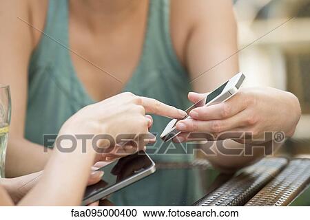 Friends pairing smartphones to exchange data View Large Photo Image Stock Image - Friends pairing smartphones to exchange data. Fotosearch