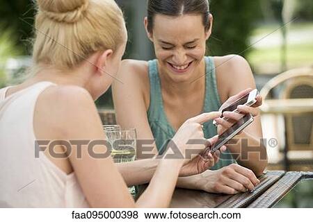 Friends share laugh over social media View Large Photo Image Stock Photo - Friends share laugh over social media. Fotosearch