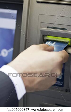Inserting bank card into ATM to perform automated banking transaction View Large Photo Image Stock Photo - Inserting bank card into ATM to perform automated banking transaction. Fotosearch