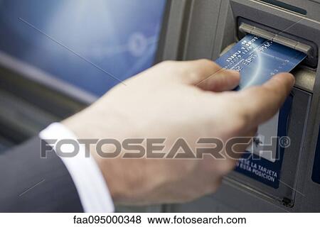 Inserting bank card into ATM to perform automated banking transaction View Large Photo Image Stock Photo - Inserting bank card into ATM to perform automated banking transaction. Fotosearch