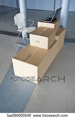 Laptop computer resting on cardboard boxes in empty office View Large Photo Image Stock Photo - Laptop computer resting on cardboard boxes in empty office. Fotosearch