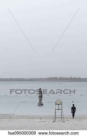 Man at the beach, walking toward water View Large Photo Image Stock Photo - Man at the beach, walking toward water. Fotosearch