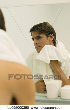 Man looking in mirror, drying face with towel View Large Photo Image Stock Image - Man looking in mirror, drying face with towel. Fotosearch