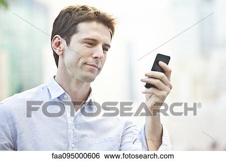 Mid-adult man checking cell phone View Large Photo Image Stock Photograph - Mid-adult man checking cell phone. Fotosearch