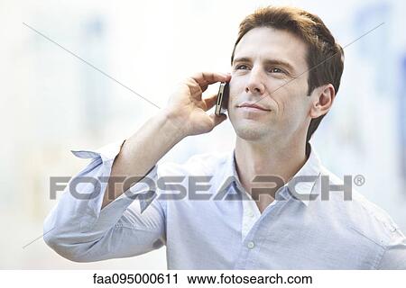 Stock Image - Mid-adult man using cell phone, portrait. Fotosearch