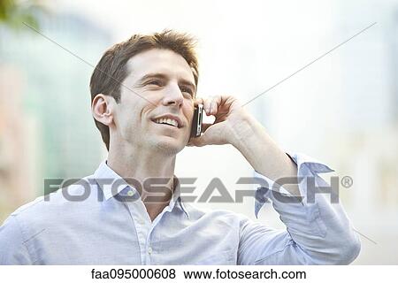 Stock Photo - Mid-adult man using cell phone, portrait. Fotosearch
