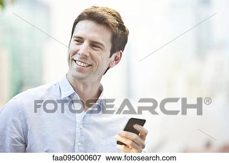 Mid-adult man using cell phone View Large Photo Image Stock Photo - Mid-adult man using cell phone. Fotosearch