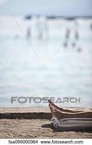 Person lying by water, low section View Large Photo Image Picture - Person lying by water, low section. Fotosearch