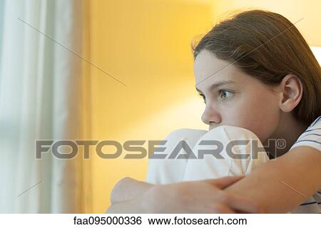 Preteen girl hugging knees, looking away in thought View Large Photo Image Stock Photograph - Preteen girl hugging knees, looking away in thought. Fotosearch