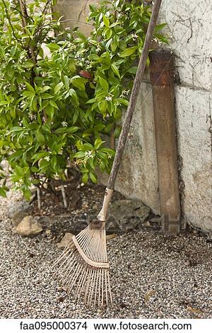 Rake leaning against stone wall View Large Photo Image Picture - Rake leaning against stone wall. Fotosearch