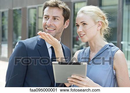 Real estate agent with digital tablet showing property to potential buyer View Large Photo Image Stock Image - Real estate agent with digital tablet showing property to potential buyer. Fotosearch