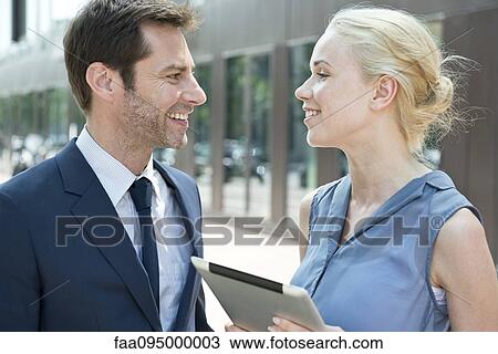 Stock Image - Real estate agent with digital tablet meeting with potential buyer. Fotosearch