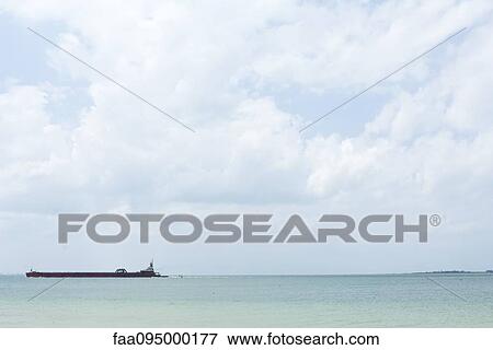 Seascape with barge visible on the horizon View Large Photo Image Stock Photo - Seascape with barge visible on the horizon. Fotosearch