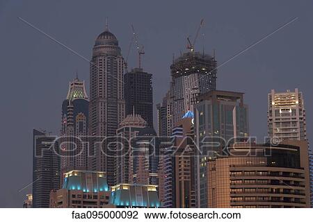 Skyscrapers illuminated at twilight, Dubai, United Arab Emirates View Large Photo Image Stock Image - Skyscrapers illuminated at twilight, Dubai, United Arab Emirates. Fotosearch