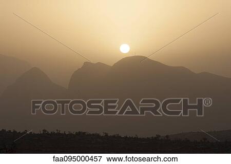 Sun setting over mountains View Large Photo Image Stock Photo - Sun setting over mountains. Fotosearch
