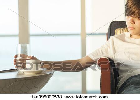 Teenage boy reaching for glass of water View Large Photo Image Stock Photo - Teenage boy reaching for glass of water. Fotosearch