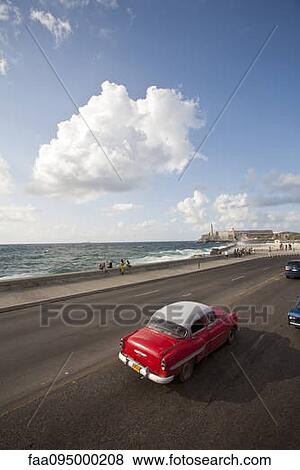 Stock Photo - Vintage car driving toward Morrow Castle, Havana, Cuba. Fotosearch