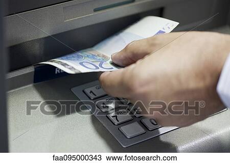Stock Image - Withdrawing cash from ATM. Fotosearch