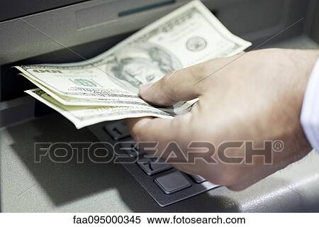 Stock Photography - Withdrawing cash from ATM. Fotosearch