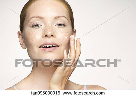 Stock Photograph - Woman moisturizing face. Fotosearch