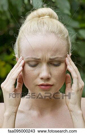 Stock Image - Woman rubbing temples. Fotosearch