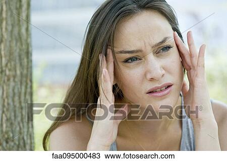 Stock Image - Woman rubbing temples. Fotosearch